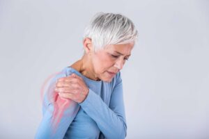 Woman experiencing frozen shoulder pain