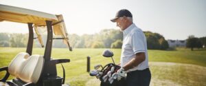 Senior golfer in Modesto putting clubs on a golf cart after recovering from shoulder replacement surgery