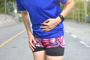 Runner holding the front of her hip in pain